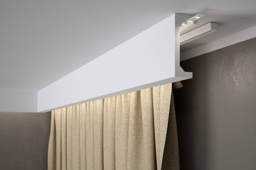 Biała listwa karniszowa QL046 Mardom Decor wykonana z trwałego materiału PolyForce, przeznaczona do estetycznego ukrycia karnisza lub szyny sufitowej oraz wykonania dekoracyjnego podświetlenia LED.